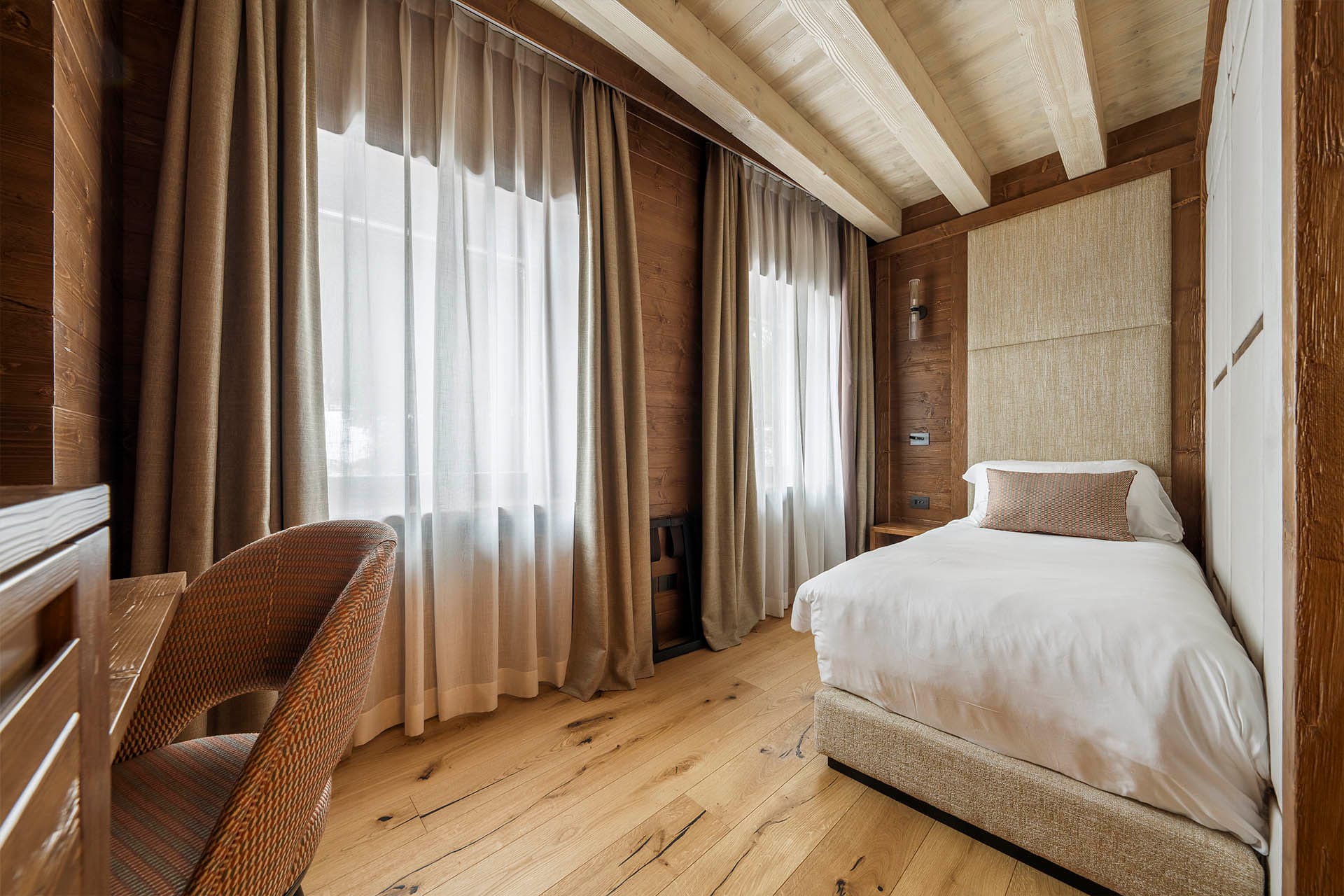 Dettaglio camera Single con letto ed ampie finestre