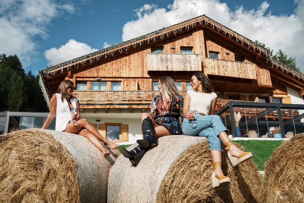 Gruppo di amiche che brindano con del vino in giardino